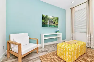 a living room with a chair and a table at Best Margaritaville Villa Near Disney World in Orlando