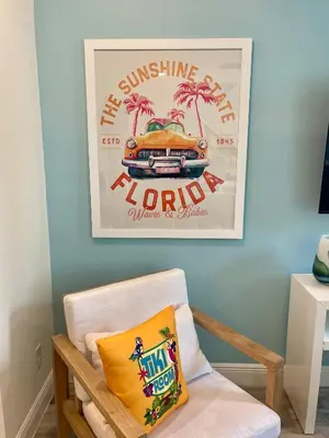 a living room with a picture of a car and a pillow at Best Margaritaville Villa Near Disney World in Orlando