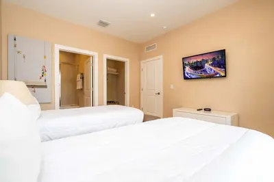 a bedroom with two beds and a tv on the wall at Modern Magic Village Home for 12 with Grill 3131 in Orlando