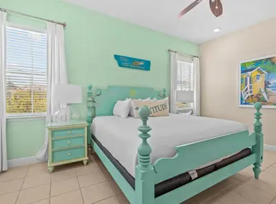 a bedroom with a blue and white bed and windows at Bikinis and Martinis - For 6 in Orlando