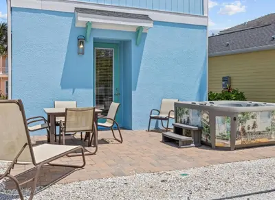 a patio with chairs and a table and a blue building at Bikinis and Martinis - For 6 in Orlando