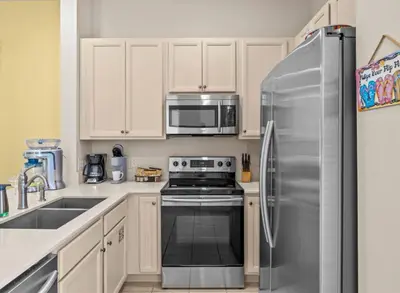 a kitchen with a stainless steel refrigerator and a microwave at Bikinis and Martinis - For 6 in Orlando