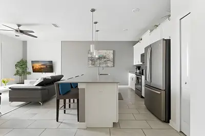 a kitchen and living room with a refrigerator and a table at Magia 4Q c/ Piscina e Quartos Temáticos Disney in Kissimmee