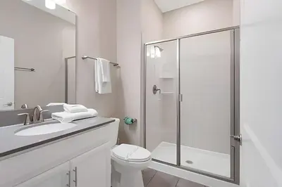 a white bathroom with a shower and a toilet at Magia 4Q c/ Piscina e Quartos Temáticos Disney in Kissimmee