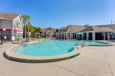 a large swimming pool in a resort building at 2 Mi to Disney and Old Town Resort Condo with Perks in Orlando