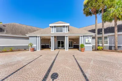 a house with palm trees and a brick driveway at 2 Mi to Disney and Old Town Resort Condo with Perks in Orlando
