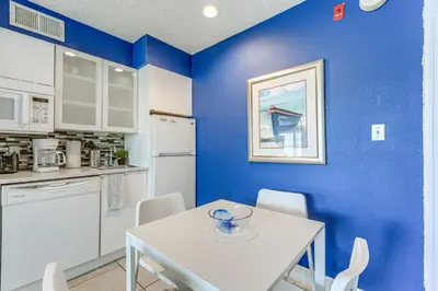 a kitchen with a white table and a blue wall at 2 Mi to Disney Resort Condo with Pool Access in Orlando