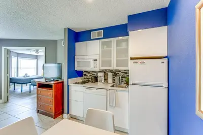 a kitchen with white appliances and a blue wall at 2 Mi to Disney Resort Condo with Pool Access in Orlando