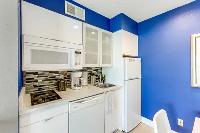 a kitchen with white appliances and blue walls at 2 Mi to Disney Resort Condo with Pool Access in Orlando