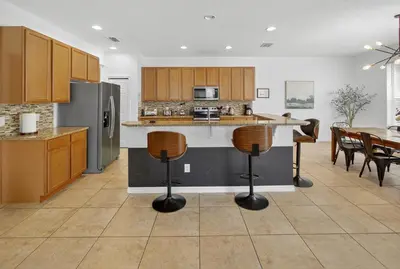 a kitchen with a island in the middle of a room at 290 LF - BellaVida Cozy 6BR Pool Home in Kissimmee