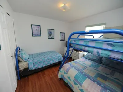 a bedroom with two beds and a bunk bed at Lake Therapy by Paradise Resort Vacations in Orlando