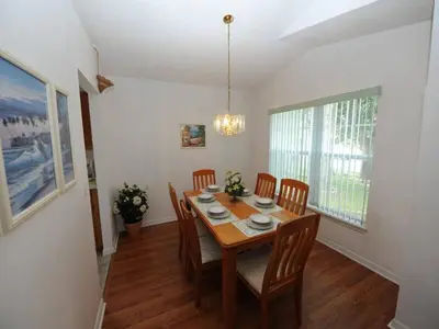 a dining room with a wooden table and chairs at Lake Therapy by Paradise Resort Vacations in Orlando