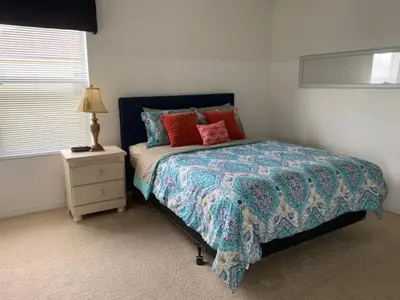 a bedroom with a bed and a night stand at Sunset Bliss Escape by Paradise Resort Vacations in Kissimmee
