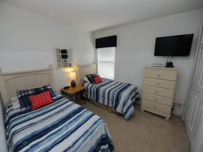 a bedroom with two beds and a television in it at Sunset Bliss Escape by Paradise Resort Vacations in Kissimmee