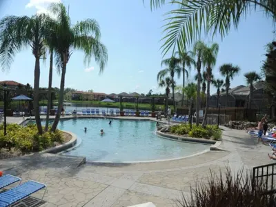 a pool at a resort with palm trees and people in it at Sunshine Oasis Villa by Paradise Resort Vacations in Kissimmee
