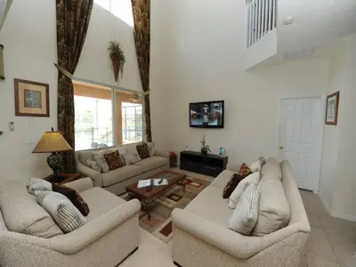 a living room with two couches and a table at Sunshine Oasis Villa by Paradise Resort Vacations in Kissimmee