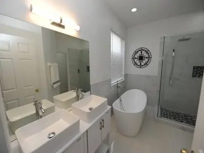 a white bathroom with two sinks and a shower at Sunshine Oasis Villa by Paradise Resort Vacations in Kissimmee