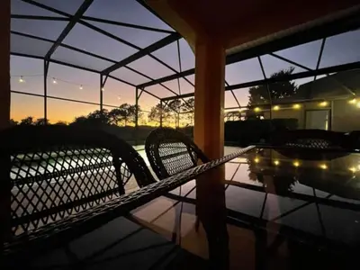 a patio with two chairs and a table with a sunset at Woodcrest Luxury by Paradise Resort Vacations in Orlando