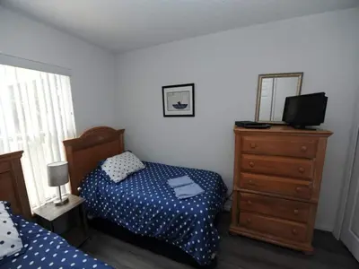 a bedroom with a bed and a dresser with a television at Palmview Villa by Paradise Resort Vacations in Orlando