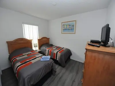 a hotel room with two beds and a television at Palmview Villa by Paradise Resort Vacations in Orlando