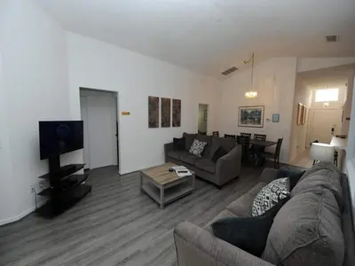 a living room with a couch and a tv at Palmview Villa by Paradise Resort Vacations in Orlando