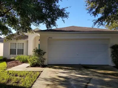 a house with a garage door in a yard at Holiday Hideout in Orlando