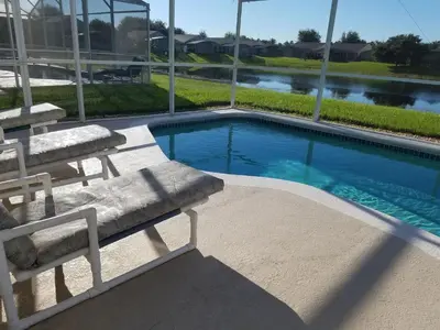 a swimming pool with two lounge chairs next to it at Holiday Hideout in Orlando