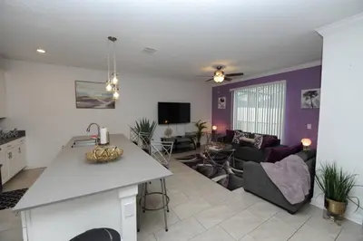 a kitchen and living room with a couch and a table at The Cove At East Storey Lake in Kissimmee