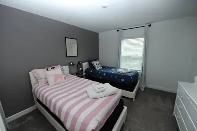 a small bedroom with a bed and a window at The Cove At East Storey Lake in Kissimmee
