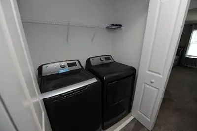 a laundry room with a washer and dryer next to a door at The Cove At East Storey Lake in Kissimmee