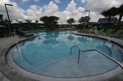 a large swimming pool with blue water in a resort at The Cove At East Storey Lake in Kissimmee