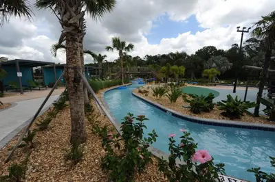 a lazy river in a resort with palm trees at The Cove At East Storey Lake in Kissimmee