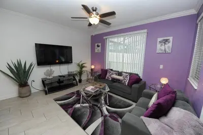 a living room with purple walls and a couch at The Cove At East Storey Lake in Kissimmee