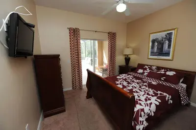 a bedroom with a bed and a flat screen tv at Tranquil Waters Haven in Kissimmee