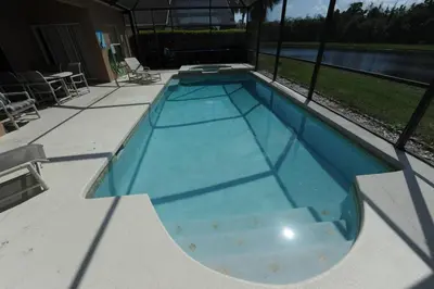 a swimming pool with blue water in a house at Tranquil Waters Haven in Kissimmee