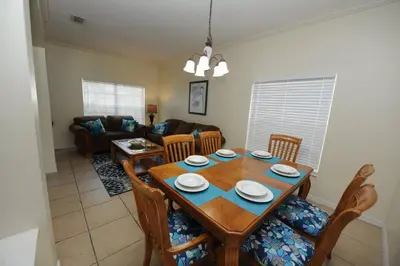 a living room with a wooden table and chairs at Tranquil Waters Haven in Kissimmee