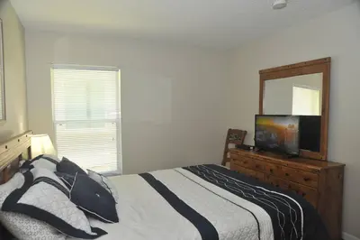 a bedroom with a bed and a mirror and a television at Serenity Retreat Near Disney in Kissimmee