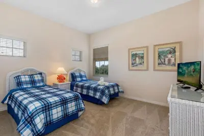 a bedroom with two beds and a television in it at Three-Bedroom Apartment Kissimmee in Orlando