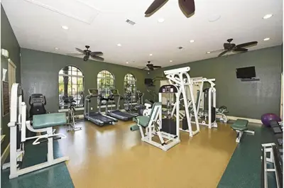 a gym with several treadmills and tread machines at Two-Bedroom Townhome Kissimmee in Orlando