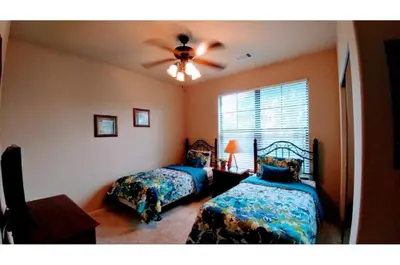 a bedroom with two beds and a ceiling fan at Two-Bedroom Townhome Kissimmee in Orlando