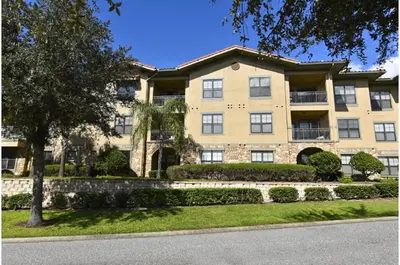 a large apartment building with a tree in front of it at Two-Bedroom Townhome Kissimmee in Orlando