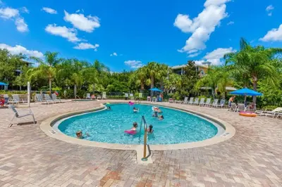 a pool at a resort with people in it at Three-Bedroom Townhome Kissimmee in Orlando