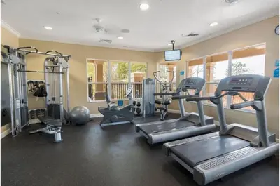 a gym with treadmills and machines in a room at Three-Bedroom Townhome Kissimmee in Orlando