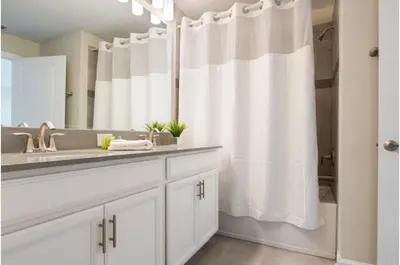 a bathroom with a sink and a shower curtain at Four-Bedroom Townhome Kissimmee in Orlando