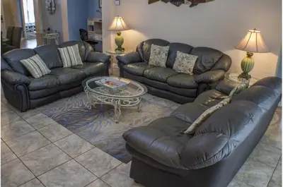 a living room with leather couches and a coffee table at Three-Bedroom Pool Home Kissimmee in Orlando