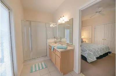 a bathroom with a shower and a sink and a bed at Three-Bedroom Pool Home Kissimmee in Orlando
