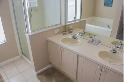 a bathroom with two sinks and a shower and a tub at Three-Bedroom Pool Home Kissimmee in Orlando