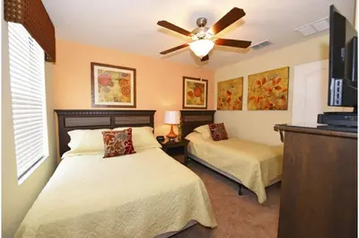 a bedroom with two beds and a ceiling fan at Five-Bedroom Pool Home Kissimmee in Orlando