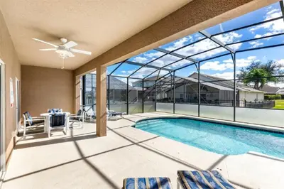 a patio with a swimming pool and glass doors at Five-Bedroom Pool Home Kissimmee in Orlando