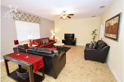 a living room with leather furniture and a ceiling fan at Five-Bedroom Pool Home Kissimmee in Orlando